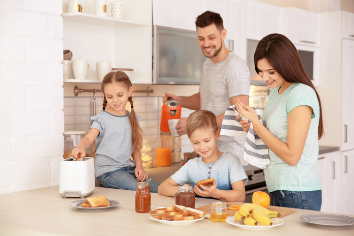 Happy-family-having-breakfast-with-toasts-in-kitchen